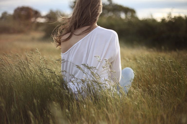 woman sitting down on a field